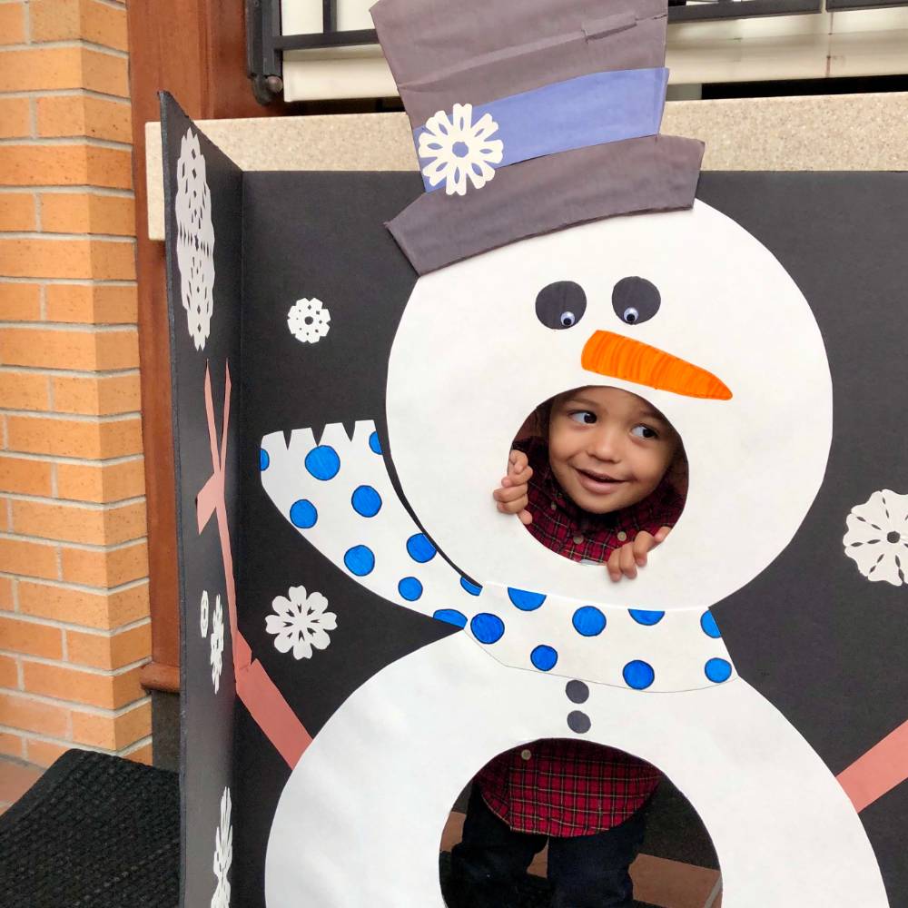 Alumni's child posing in snowman cut out